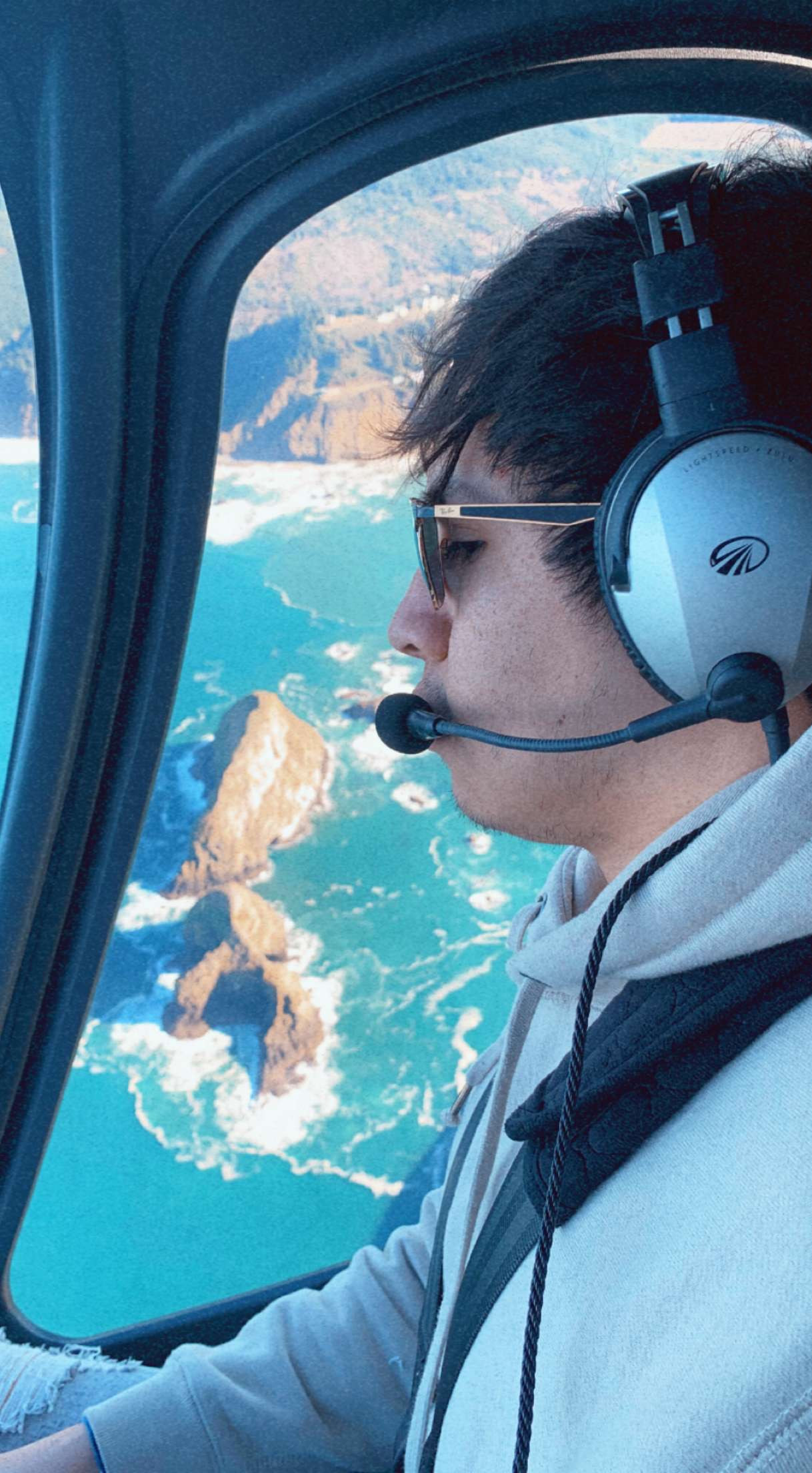 Rey Garza flying over a sea-arch off the Western Oregon coast