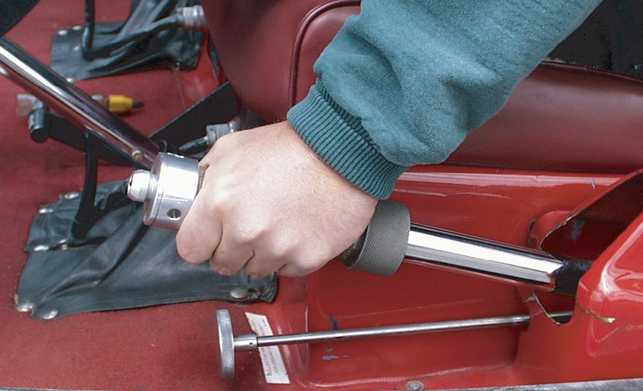 Photograph of a pilot's left hand on a helicopter collective lever, with the twist-grip throttle at its end.